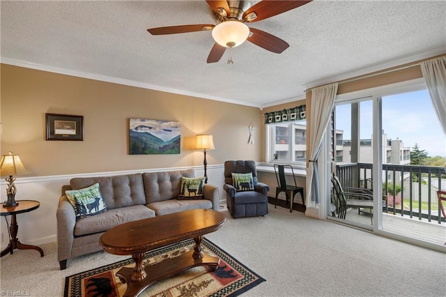 carpeted living room featuring a textured ceiling, ceiling fan, and ornamental molding