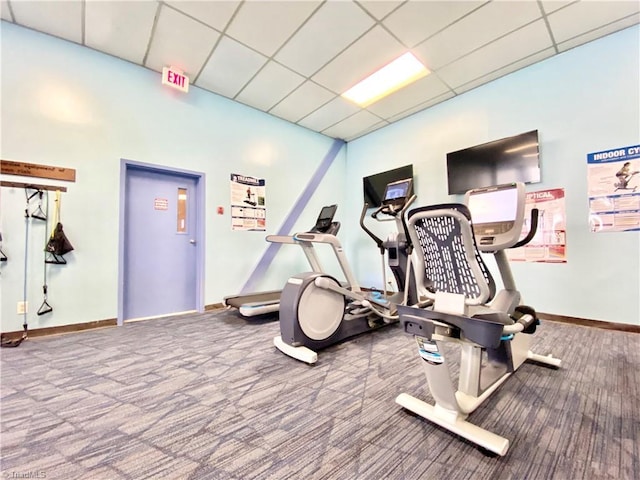 exercise room featuring a paneled ceiling and carpet flooring