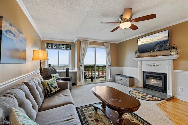 living room featuring a textured ceiling, ceiling fan, and crown molding