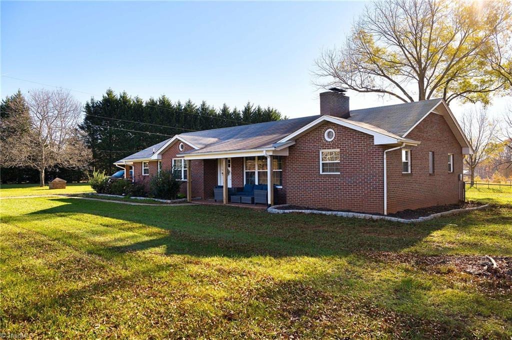 ranch-style home with a porch and a front lawn