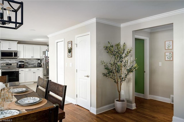 dining space with hardwood / wood-style flooring and crown molding