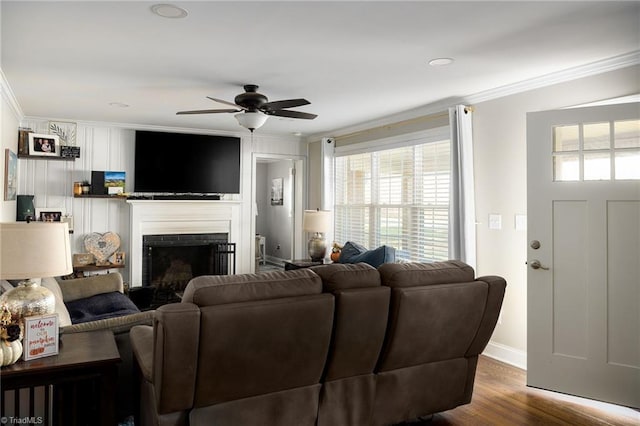 living room featuring hardwood / wood-style flooring, ceiling fan, and ornamental molding