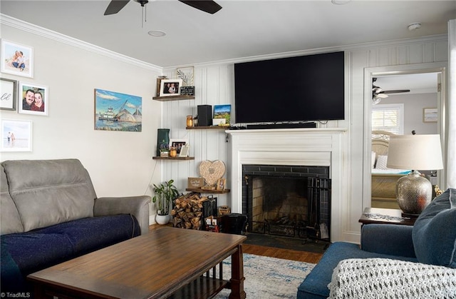 living room featuring ceiling fan, dark hardwood / wood-style flooring, and crown molding