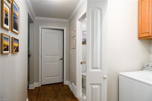 washroom featuring dark hardwood / wood-style floors, cabinets, ornamental molding, and washer / clothes dryer