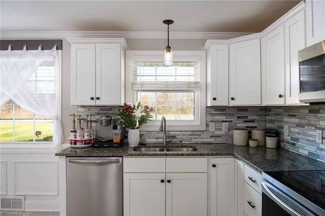 kitchen featuring a wealth of natural light, sink, hanging light fixtures, white cabinets, and appliances with stainless steel finishes