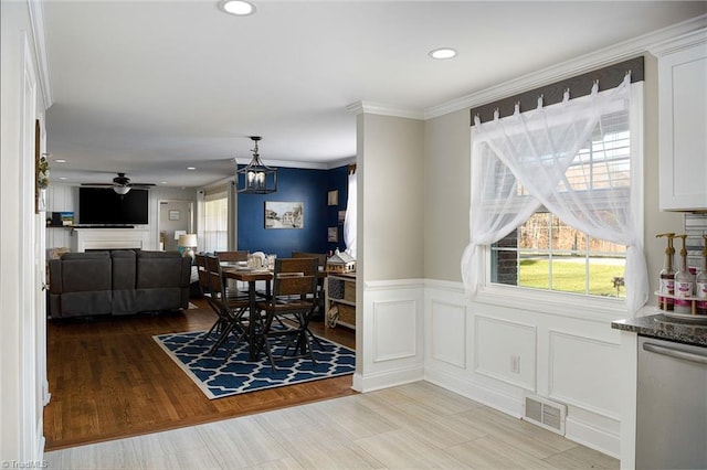 dining space with ceiling fan and crown molding