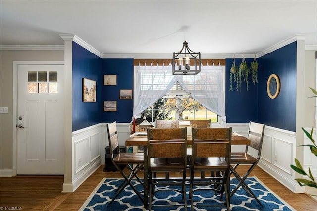 dining space featuring hardwood / wood-style flooring, a notable chandelier, and ornamental molding