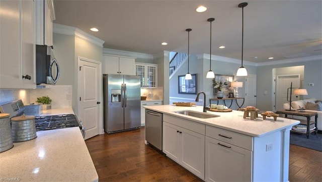 kitchen featuring appliances with stainless steel finishes, dark hardwood / wood-style flooring, sink, and an island with sink