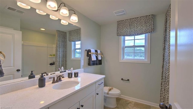 bathroom with vanity, tile patterned flooring, toilet, and a wealth of natural light