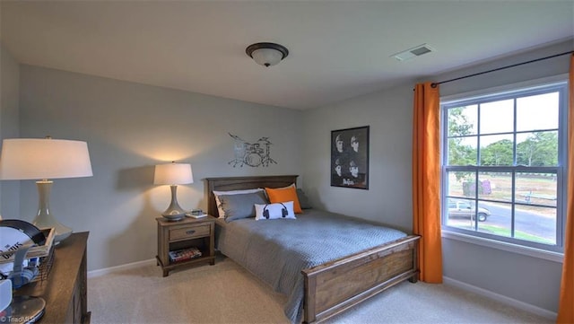 bedroom with light carpet and multiple windows