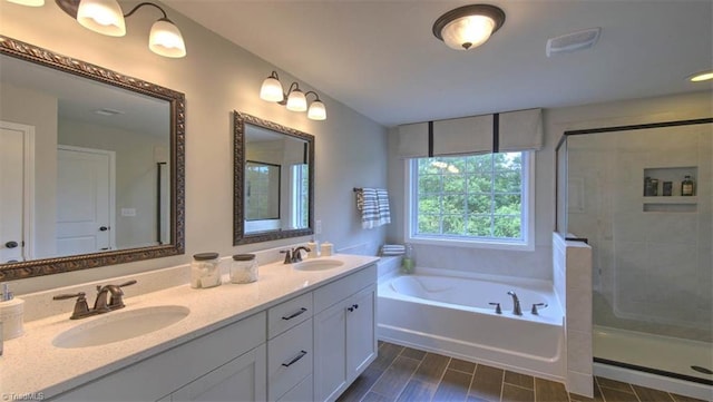 bathroom featuring vanity and independent shower and bath