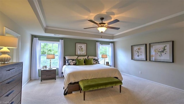 carpeted bedroom with a raised ceiling, multiple windows, and ceiling fan