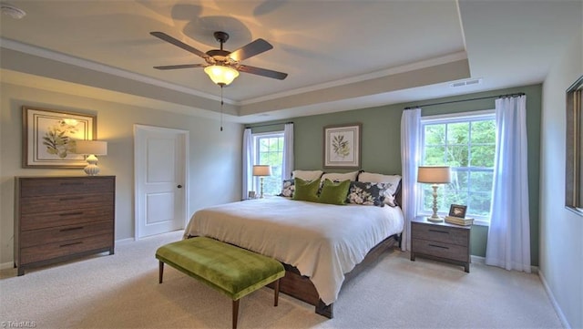 bedroom with light colored carpet, ceiling fan, crown molding, and a raised ceiling