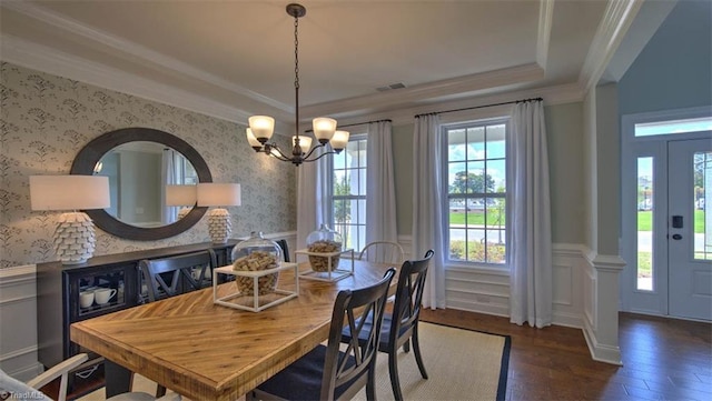 dining space with crown molding, an inviting chandelier, and dark hardwood / wood-style flooring