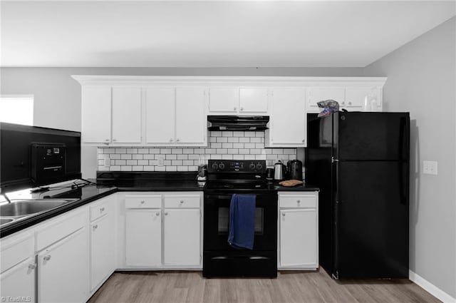 3304 Spring St, Greensboro, NC 27405 - kitchen with under cabinet range hood, white cabinetry, black appliances, tasteful backsplash, and light wood-type flooring