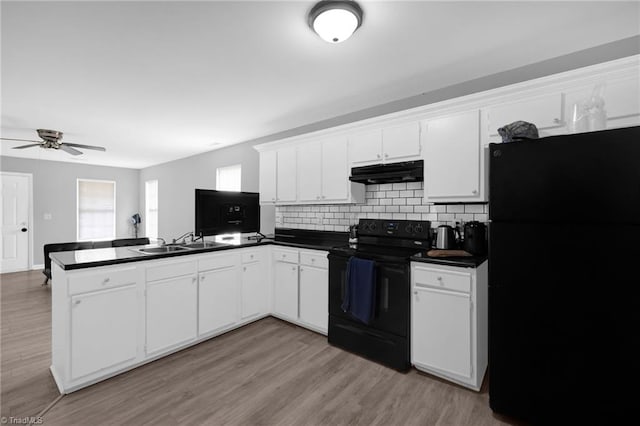 3304 Spring St, Greensboro, NC 27405 - kitchen featuring a peninsula, a sink, dark countertops, black appliances, and under cabinet range hood