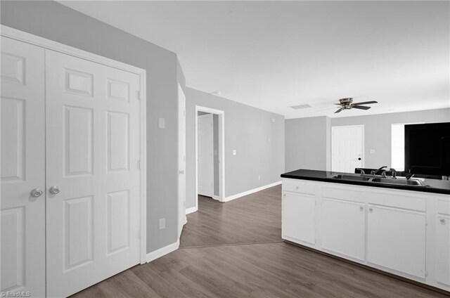 3304 Spring St, Greensboro, NC 27405 - kitchen with a sink, dark wood-style floors, white cabinets, baseboards, and dark countertops
