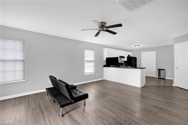3304 Spring St, Greensboro, NC 27405 - unfurnished living room with ceiling fan, dark wood-style flooring, baseboards, and visible vents