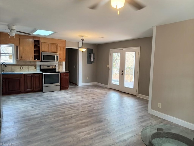 kitchen featuring stainless steel appliances, plenty of natural light, light countertops, and a sink