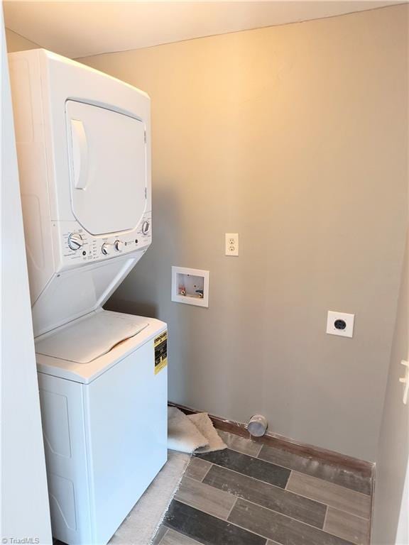 clothes washing area featuring laundry area and stacked washing maching and dryer