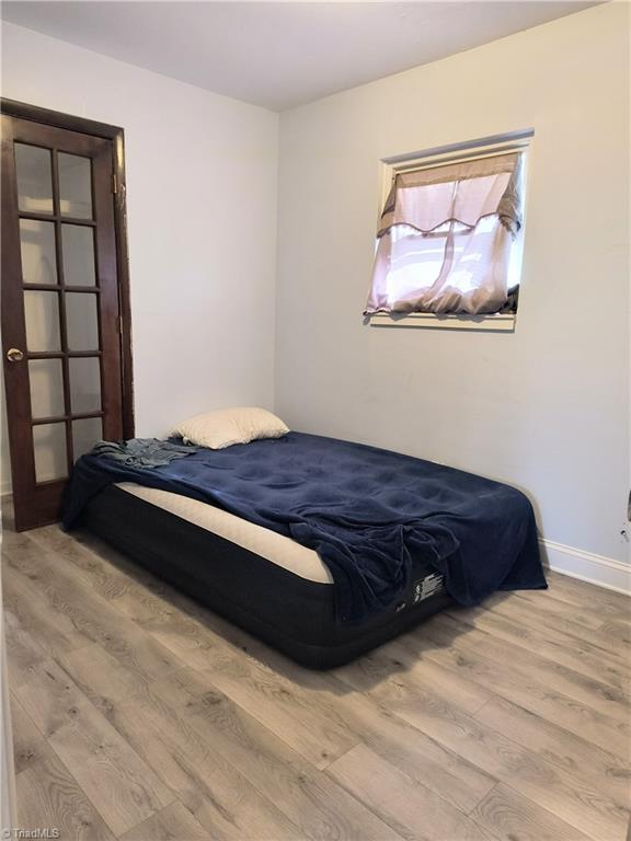 bedroom with baseboards and wood finished floors