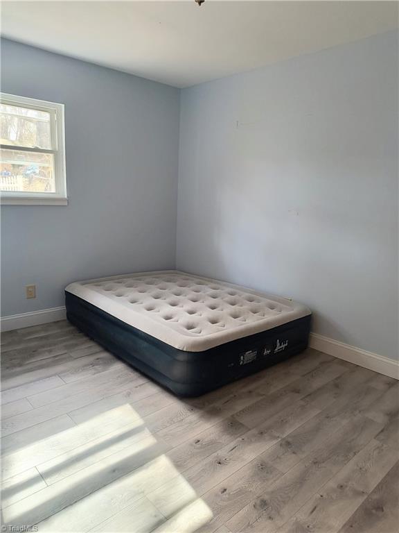 unfurnished bedroom featuring baseboards and wood finished floors