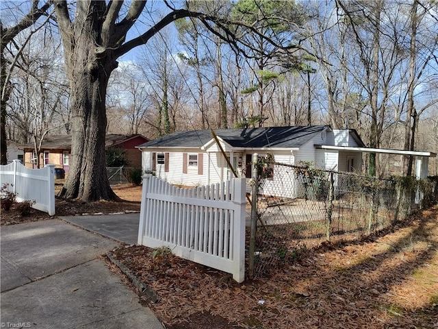 view of front facade with a fenced front yard and aphalt driveway