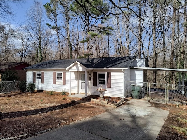 ranch-style house with driveway, a gate, fence, and a carport