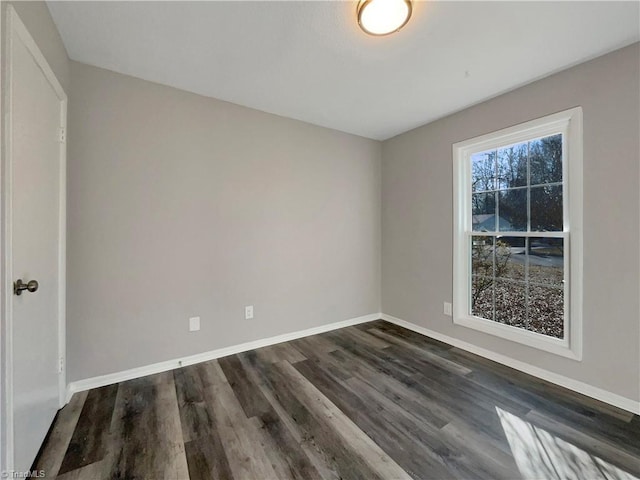 empty room with dark hardwood / wood-style flooring