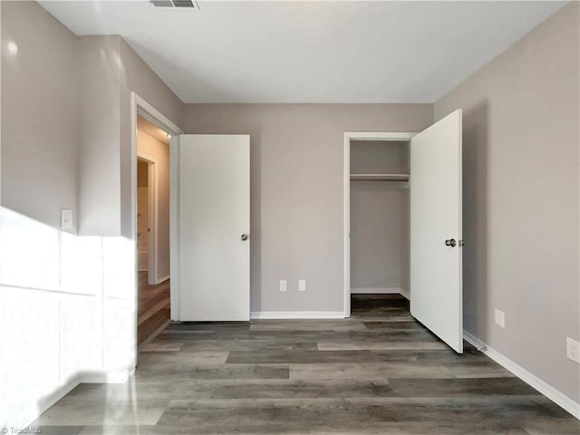 unfurnished bedroom featuring dark hardwood / wood-style floors and a closet