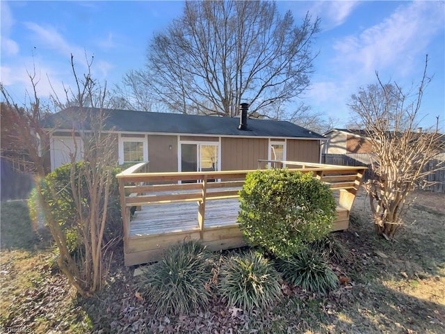 rear view of property featuring a wooden deck