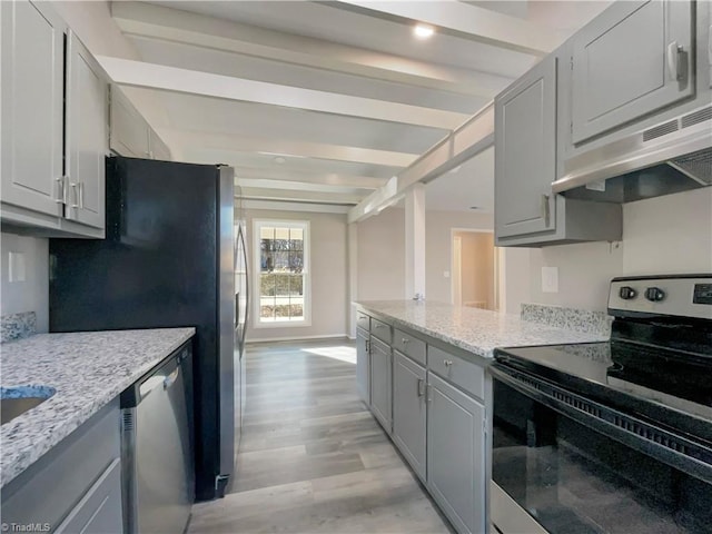 kitchen featuring light wood-type flooring, light stone countertops, gray cabinets, appliances with stainless steel finishes, and beamed ceiling