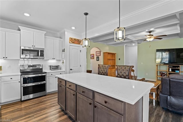 kitchen featuring white cabinetry, arched walkways, stainless steel appliances, and open floor plan