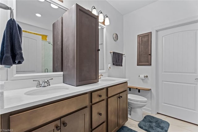 bathroom featuring double vanity, toilet, a sink, and a shower with shower door