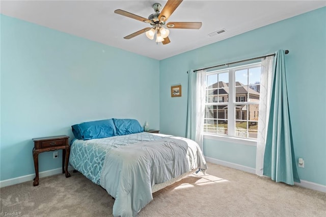 carpeted bedroom with visible vents, ceiling fan, and baseboards