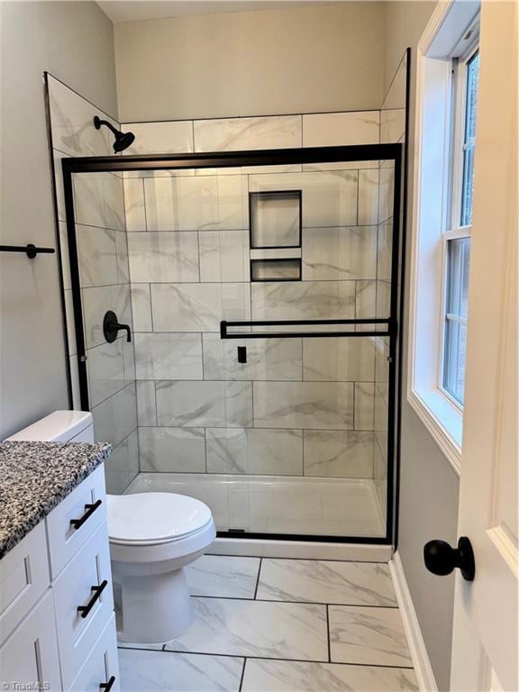 bathroom with vanity, an enclosed shower, and toilet