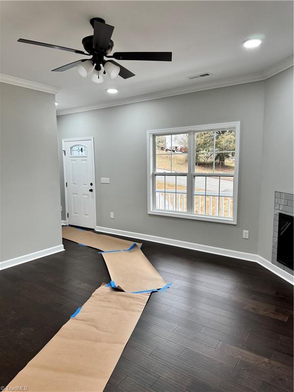 exercise room with dark hardwood / wood-style flooring, ornamental molding, and ceiling fan