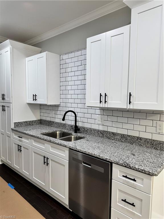 kitchen featuring sink, crown molding, dishwasher, light stone countertops, and white cabinets