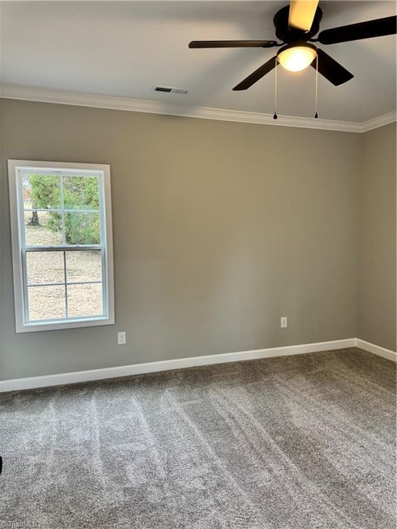 carpeted empty room featuring crown molding and ceiling fan