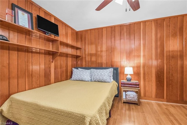 bedroom with wood walls and wood finished floors