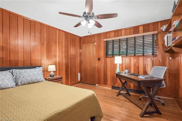 bedroom featuring wooden walls and wood finished floors