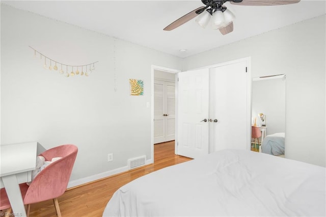 bedroom featuring visible vents, wood finished floors, baseboards, and ceiling fan