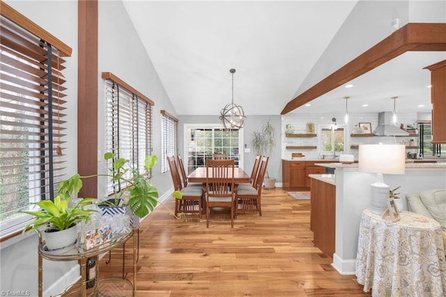 dining area featuring baseboards, light wood finished floors, high vaulted ceiling, an inviting chandelier, and recessed lighting