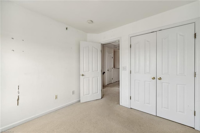 unfurnished bedroom featuring carpet flooring, baseboards, and a closet