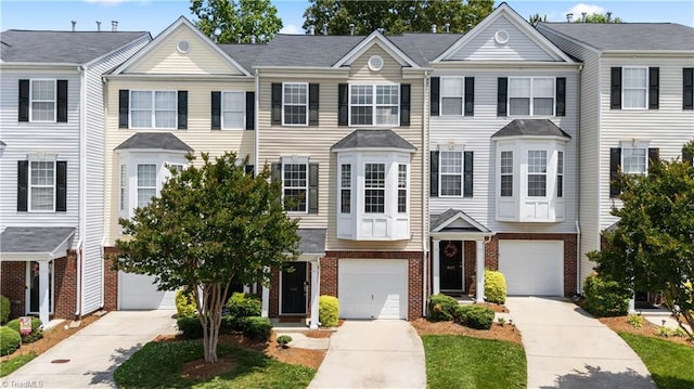 townhome / multi-family property featuring brick siding, driveway, and an attached garage