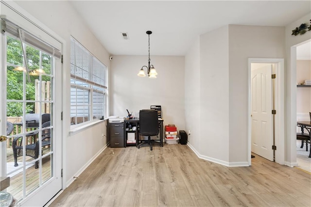home office with plenty of natural light, light wood finished floors, baseboards, and a chandelier