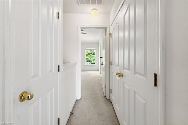 hallway featuring light colored carpet