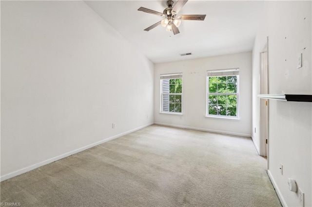 empty room featuring carpet floors, a ceiling fan, baseboards, and vaulted ceiling