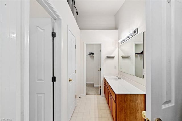bathroom featuring vanity, a closet, and baseboards
