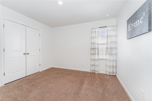 unfurnished bedroom featuring carpet flooring and a closet